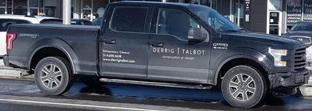 Sample CarGo still: a black Ford F-150 in profile in front of a storefront, driver blurred